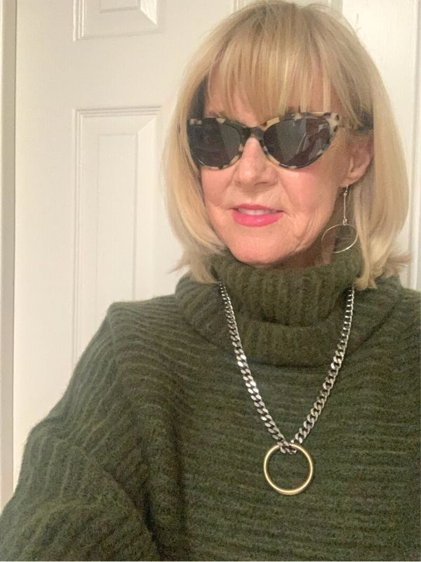 model in sweater with necklace & earrings